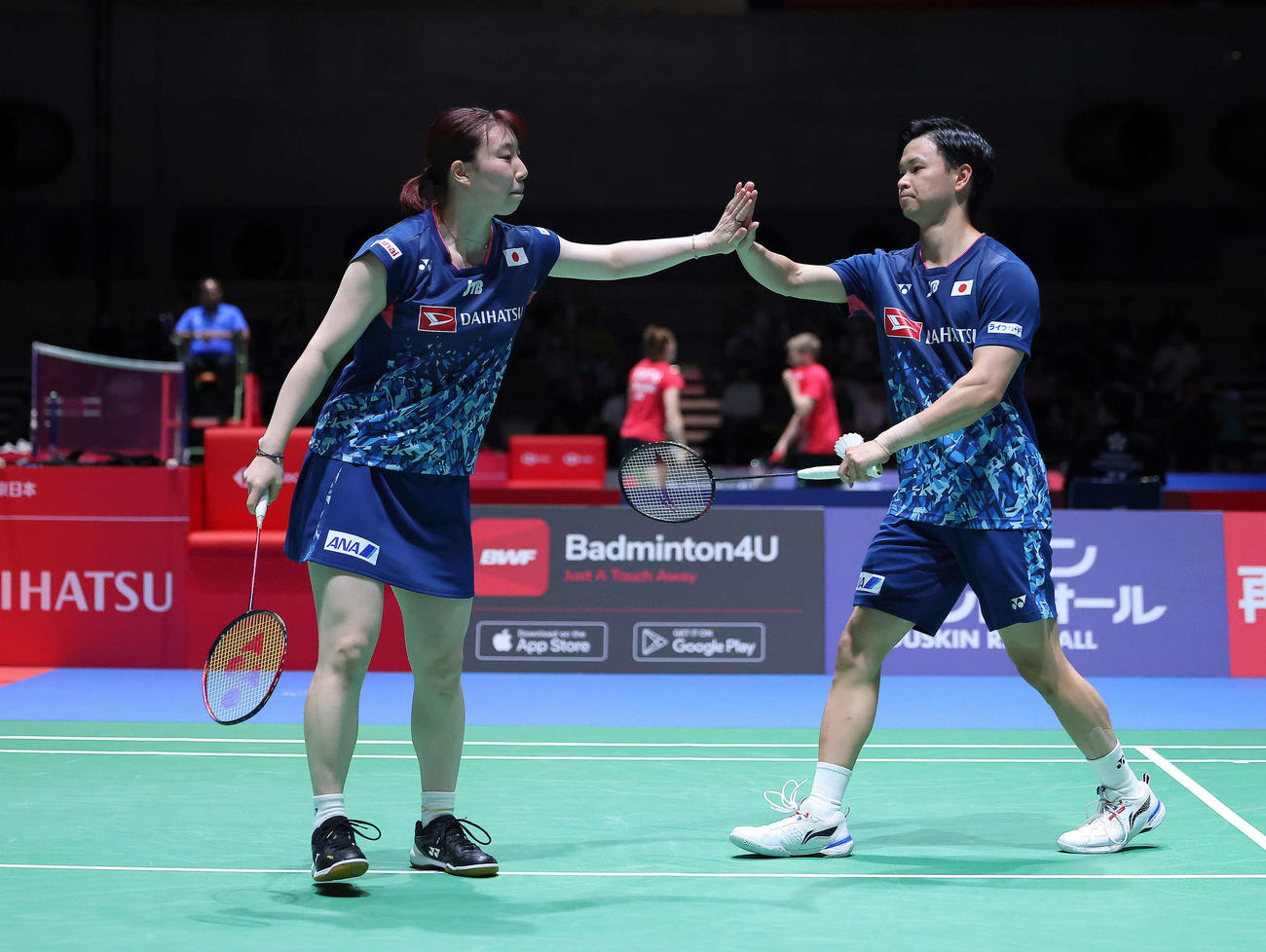 混合ダブルス2回戦　ポイントしタッチを交わす東野（左）と渡辺（撮影・河田真司）