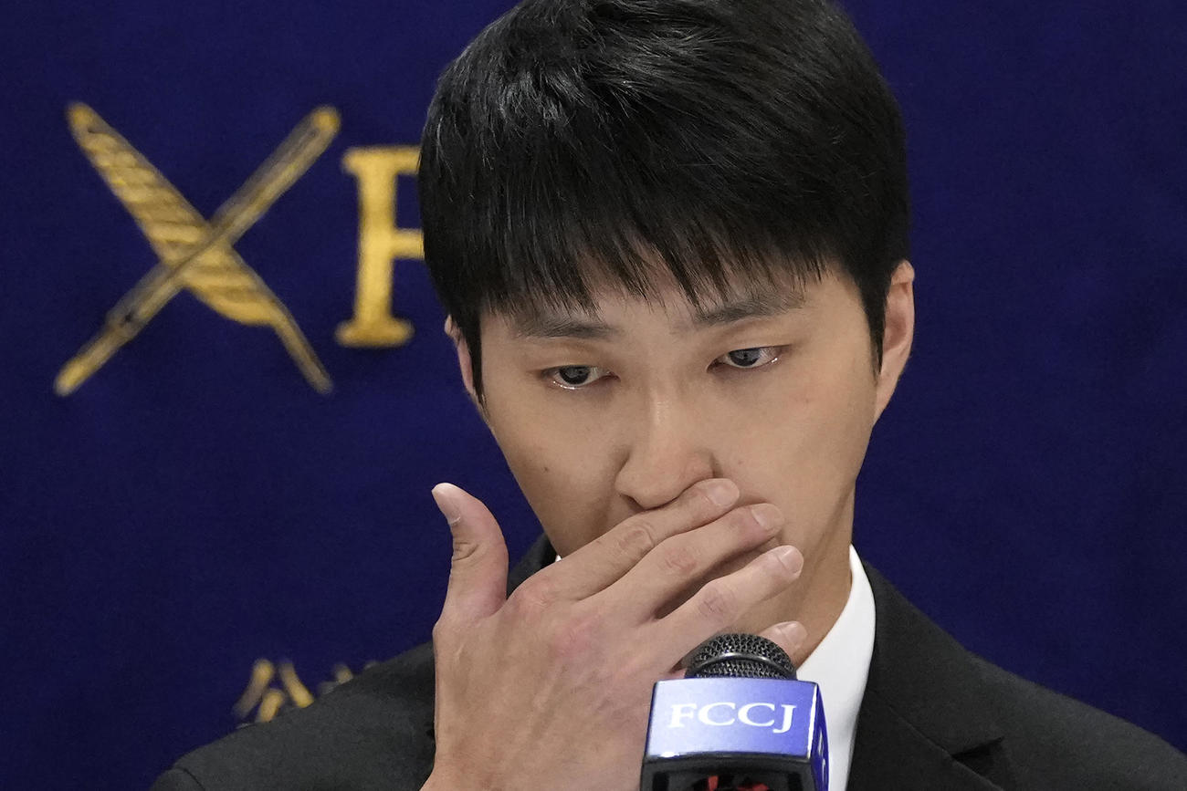 会見で涙を流す江宏傑氏（AP）