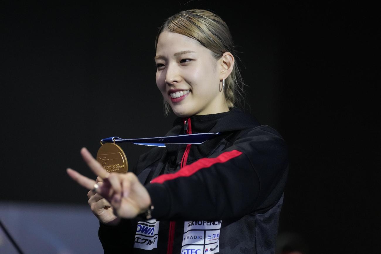 表彰式後、金メダルを手に笑顔でピースサインの江村美咲（AP）