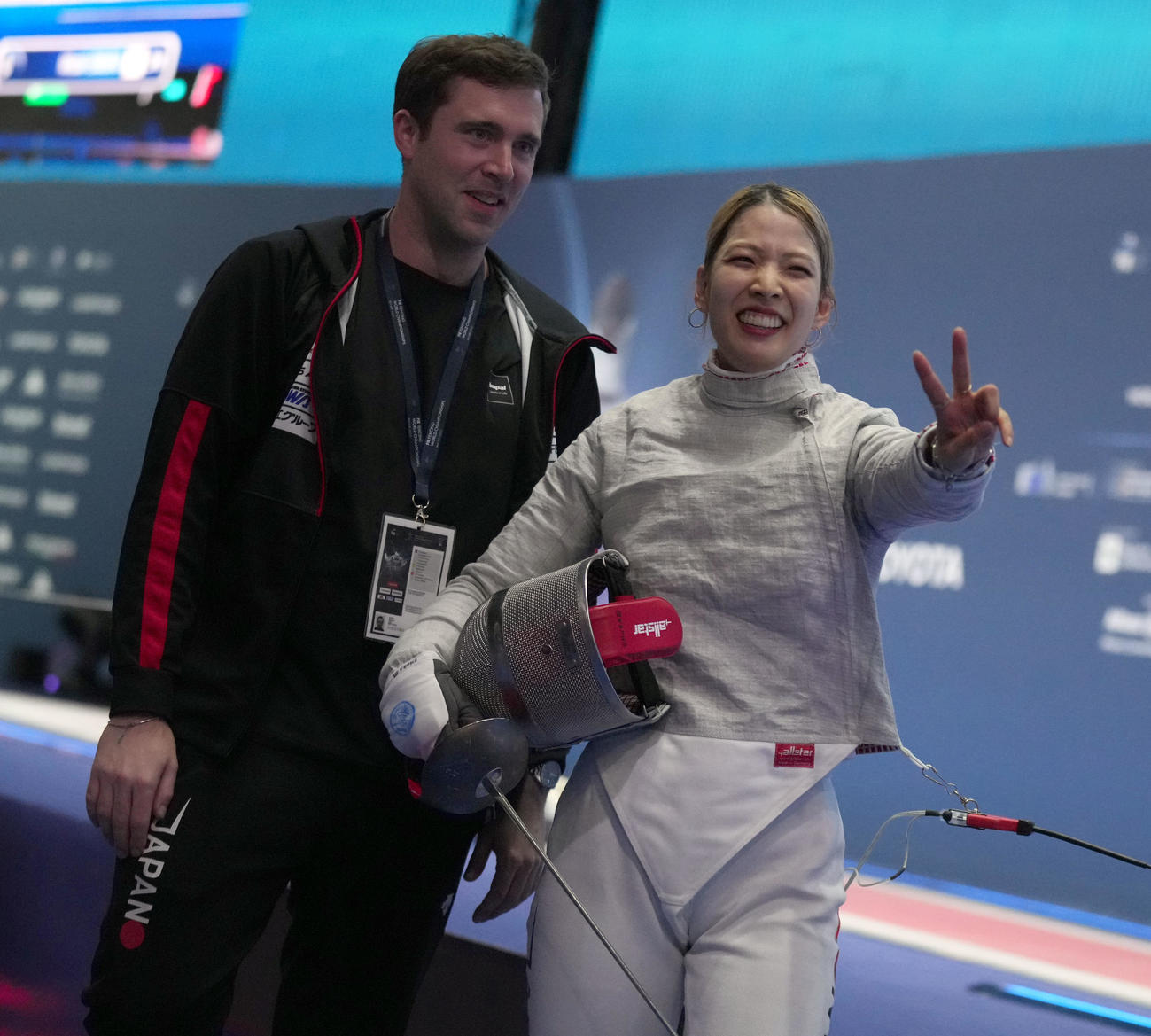 フェンシング世界選手権の女子サーブルで日本勢初の2連覇を遂げ、関係者にピースの江村美咲。左はジェローム・コーチ(C)日本協会／Augusto Bizzi／FIE