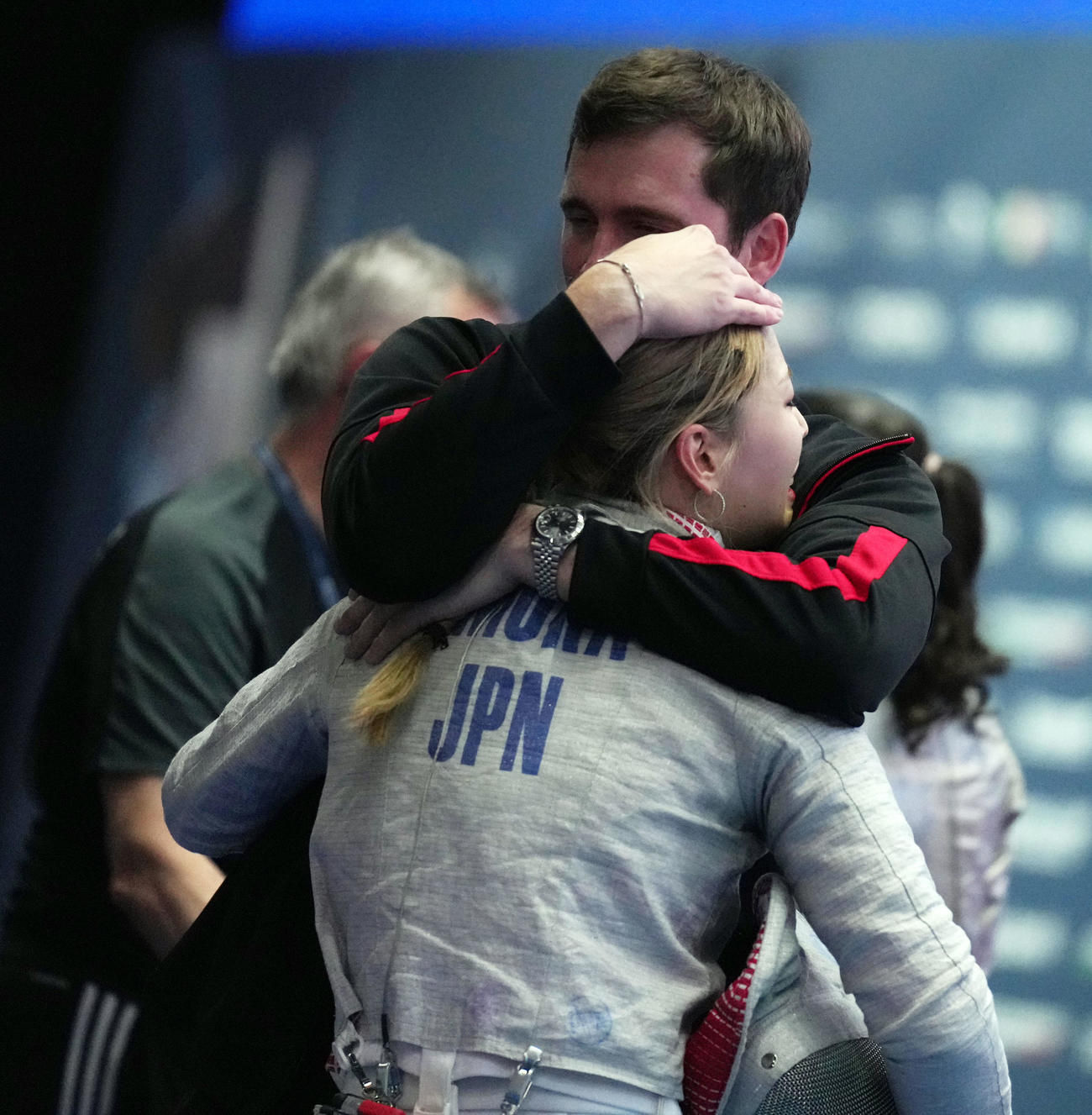 フェンシング世界選手権の女子サーブルで日本勢初の2連覇を遂げ、ジェローム・コーチに抱きしめられる江村美咲(C)日本協会／Augusto Bizzi／FIE
