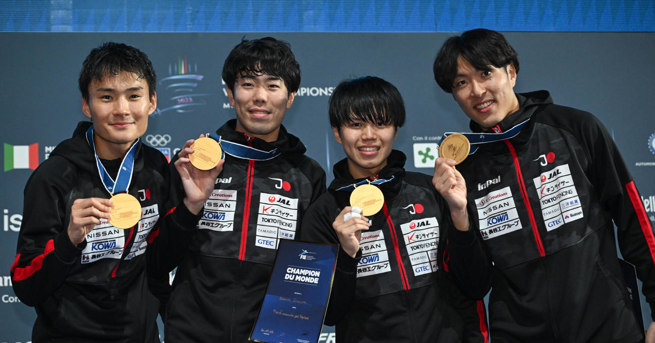 フェンシング世界選手権の男子フルーレ団体で初の金メダルを獲得し、誇らしげに掲げる日本代表。左から松山恭助、敷根崇裕、飯村一輝、鈴村健太（C）日本協会／Augusto Bizzi／FIE