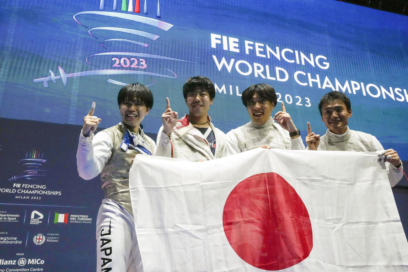 フェンシングの世界選手権男子フルーレ団体で金メダルを獲得し、日の丸を掲げる日本の（右から）松山、鈴村、敷根、飯村＝ミラノ（AP＝共同）