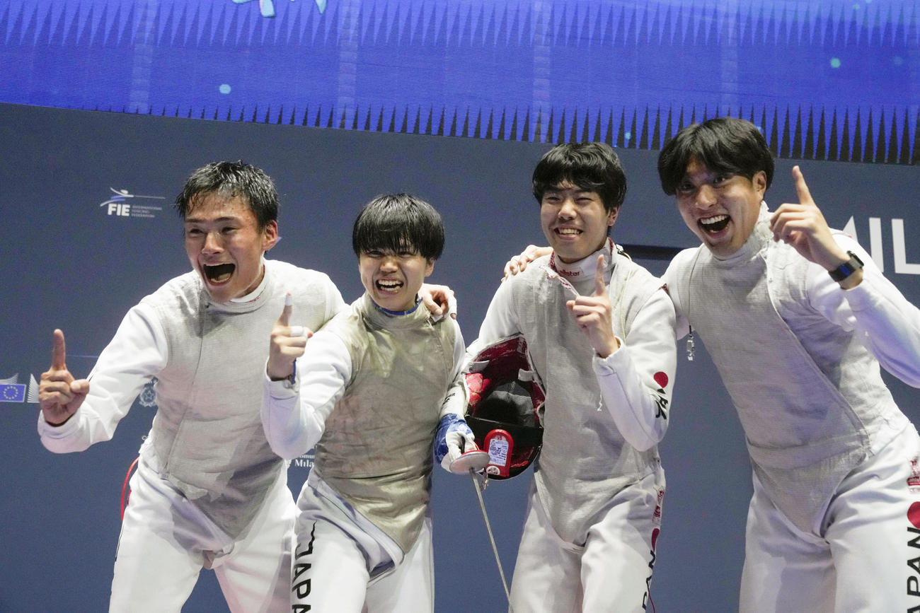 フェンシングの世界選手権男子フルーレ団体で優勝し、ポーズを取る日本の（左から）松山、飯村、敷根、鈴村＝ミラノ（AP＝共同）
