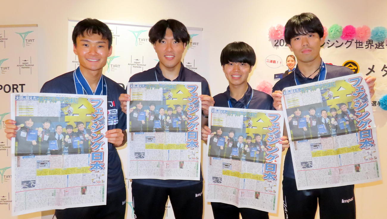 男子フルーレ団体で初の金メダルを獲得したフェンシング世界選手権から帰国し、快挙翌日付の本紙を手に笑顔を見せる左から松山恭助、鈴村健太、飯村一輝、敷根崇裕（撮影・木下淳）