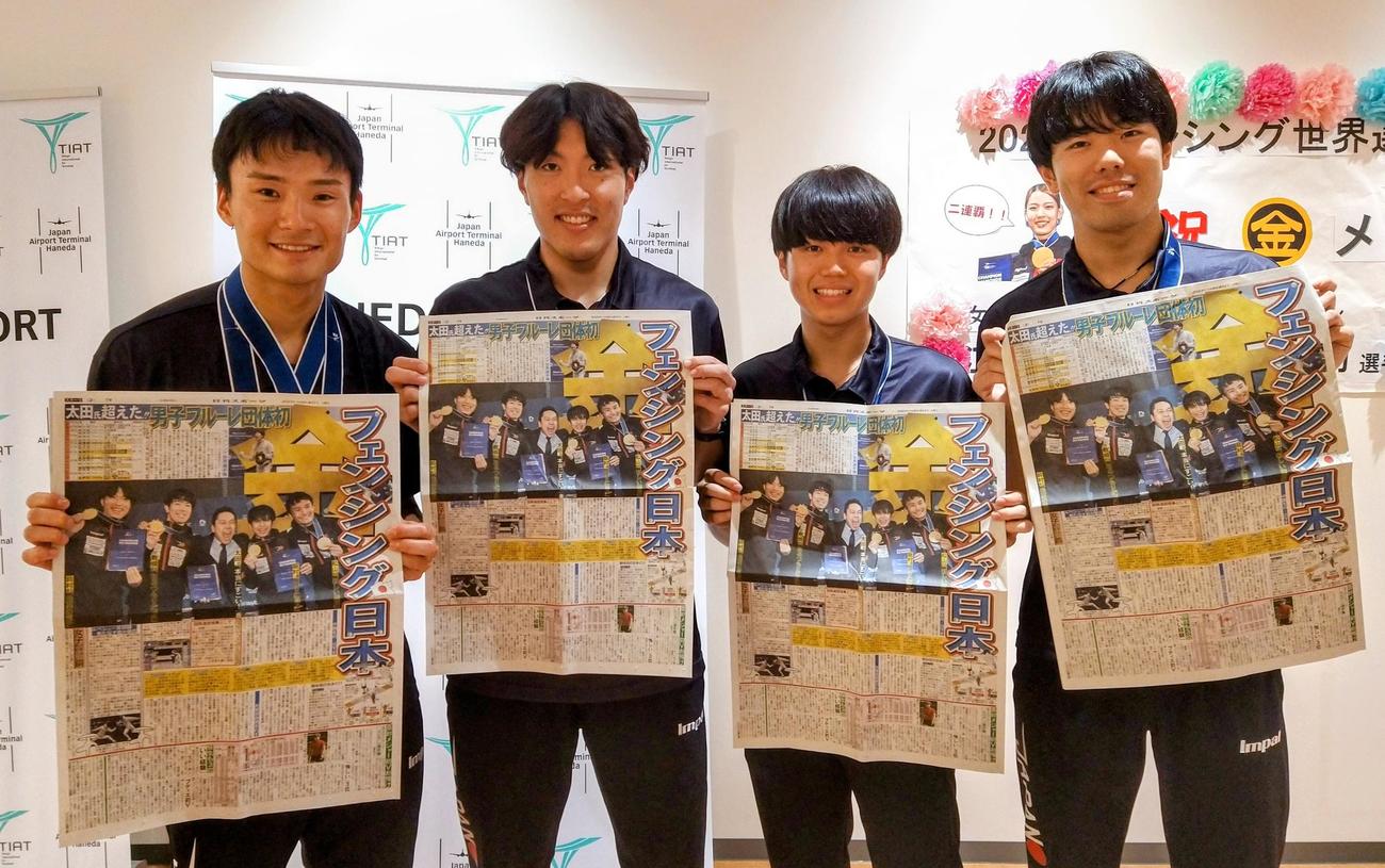 男子フルーレ団体で初の金メダルを獲得したフェンシング世界選手権から帰国し、快挙翌日付の本紙を手に笑顔を見せる、左から松山、鈴村、飯村、敷根（撮影・木下淳）