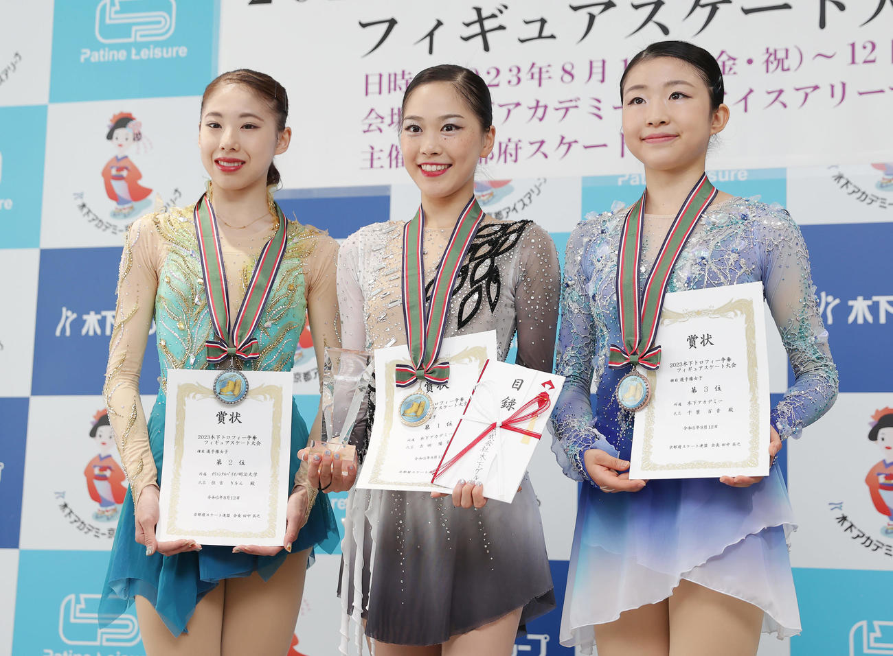 女子フリーで優勝し、トロフィーを手に笑顔を見せる吉田。左は2位住吉、右は3位千葉（撮影・前田充）
