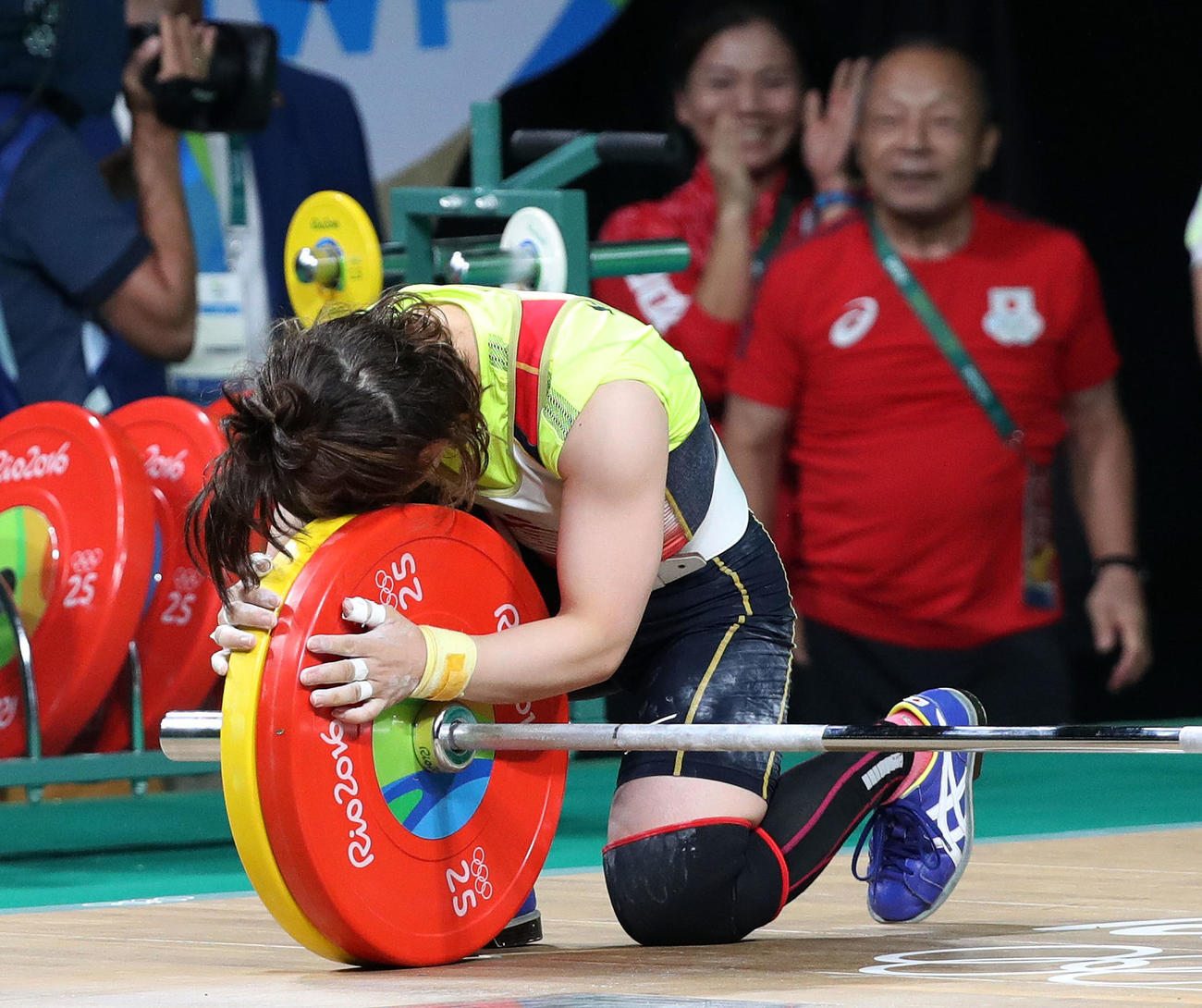 16年8月、リオデジャネイロ五輪重量挙げ女子48キロ級で、ジャーク107キロを成功させ、バーベルに抱きつき喜ぶ三宅。後方は父義行氏