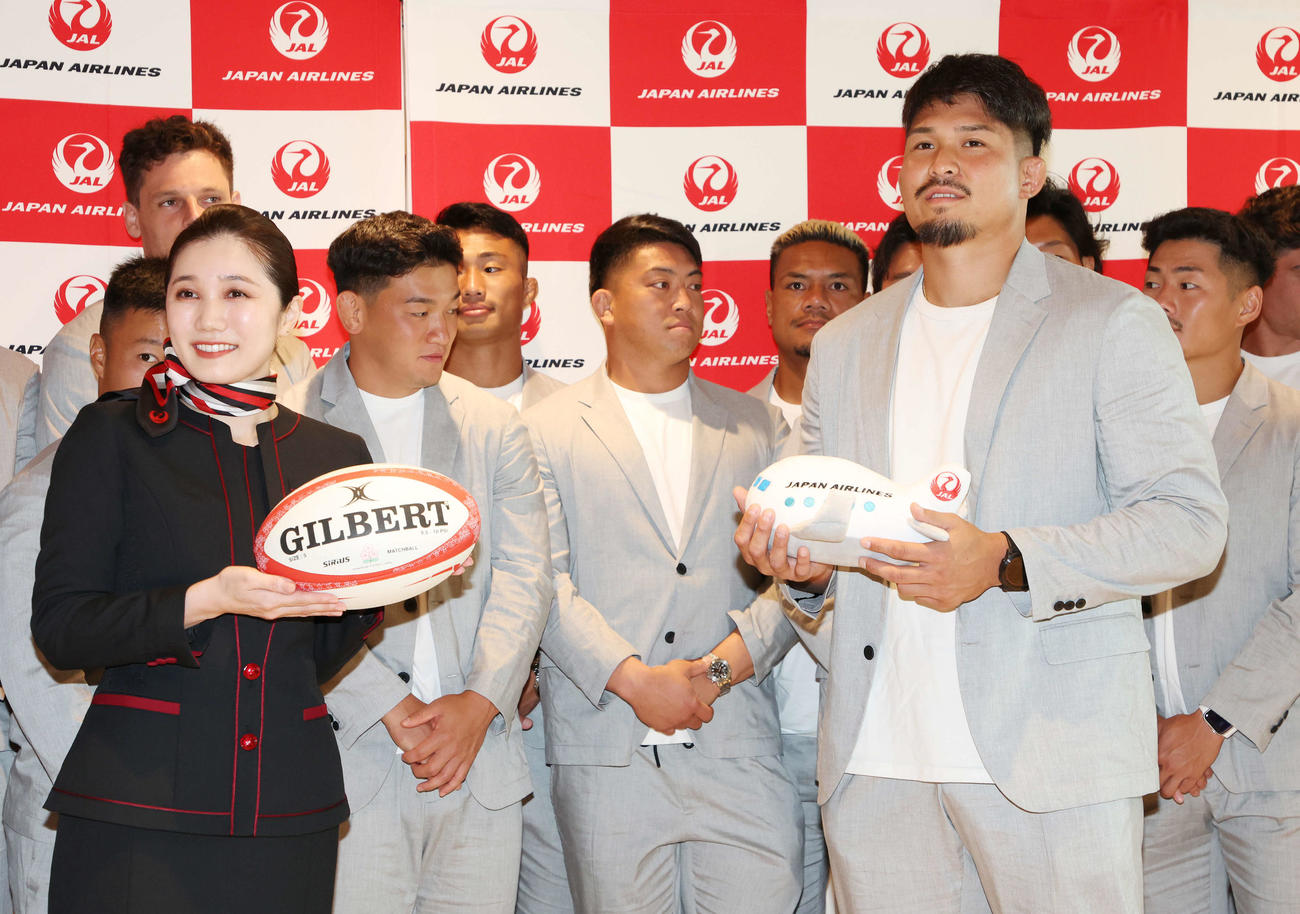 ラグビー日本代表出発式でラグビーボールを渡し、記念品を受け取った姫野主将（手前右）（撮影・宮地輝）