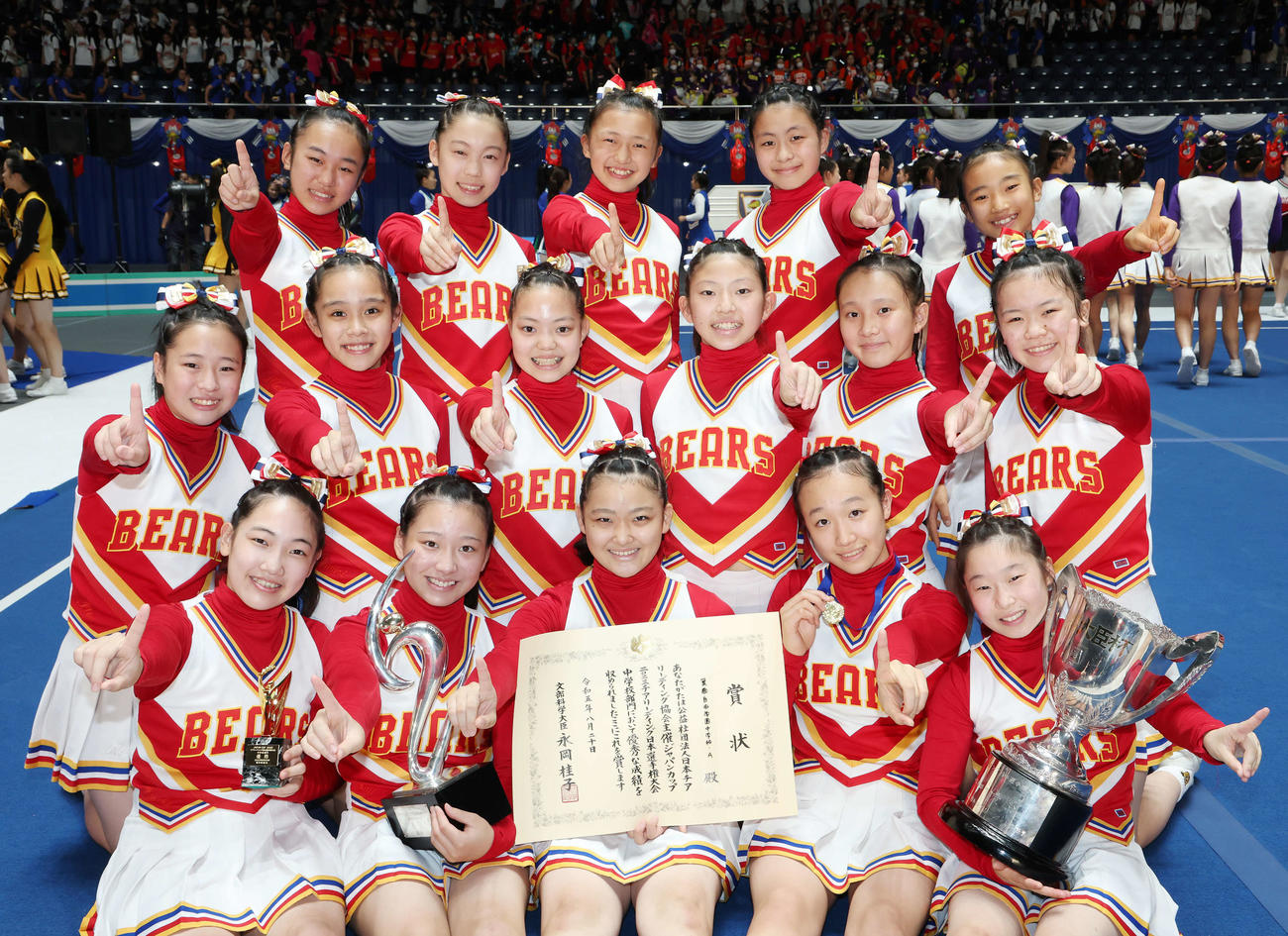 中学校部門を優勝し、笑顔で記念撮影する箕面自由学園中学校チアリーディング部（撮影・宮地輝）