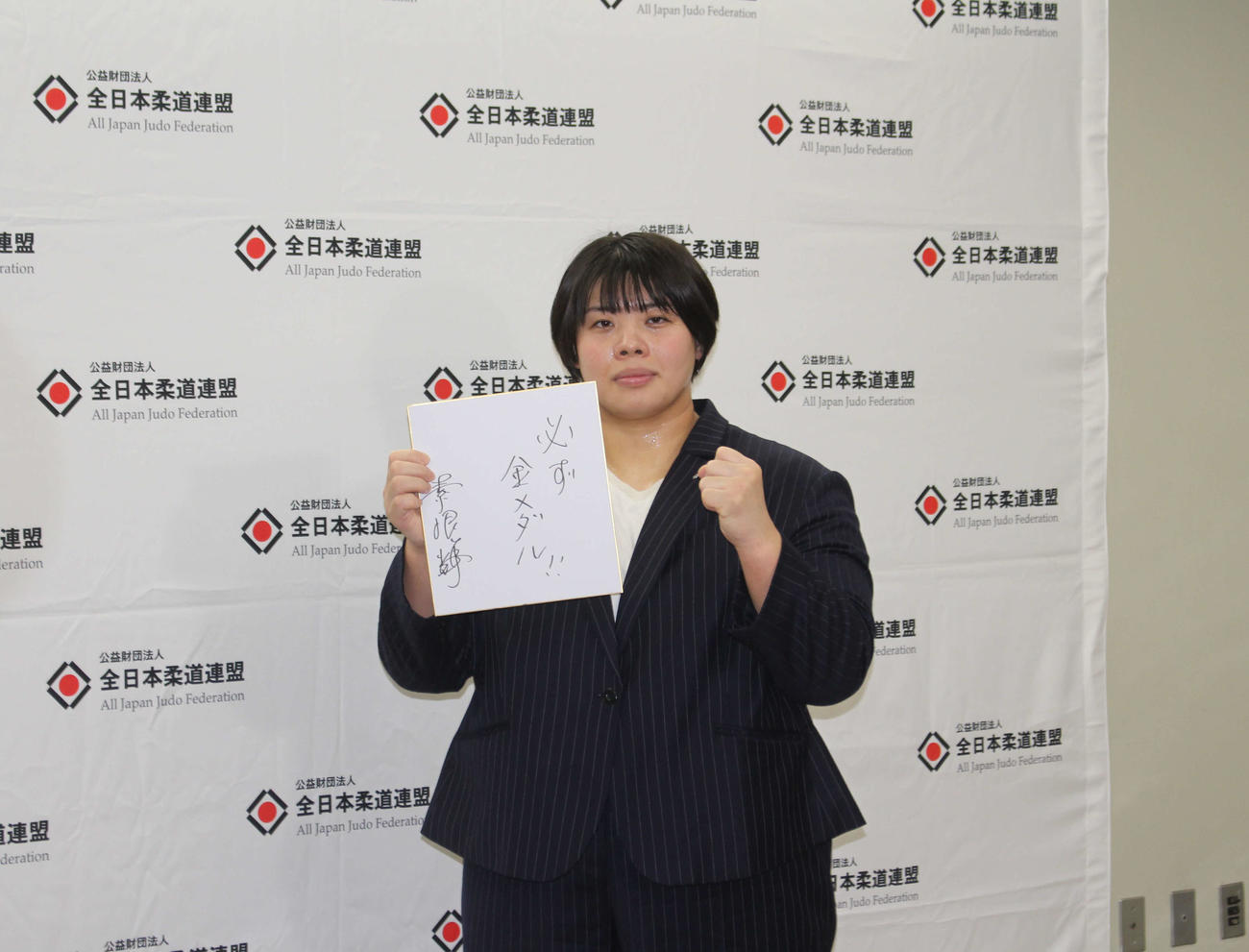「必ず金メダル」を書いた色紙を手にする素根