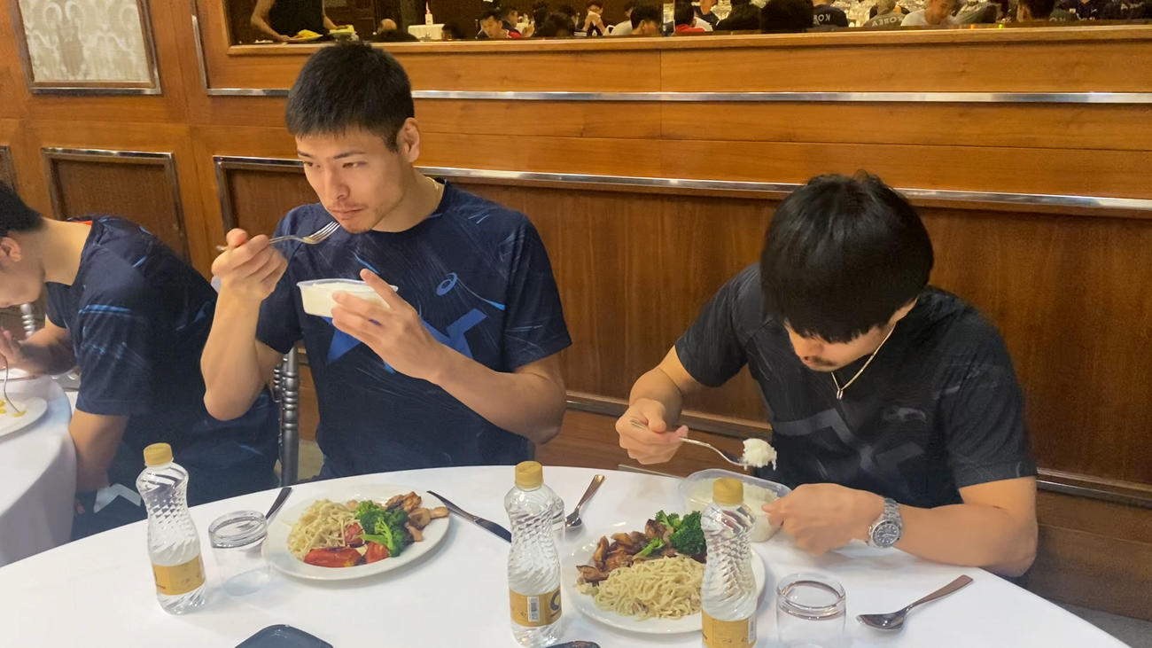 白米を食べる高橋健（左）と関田（C）JVA
