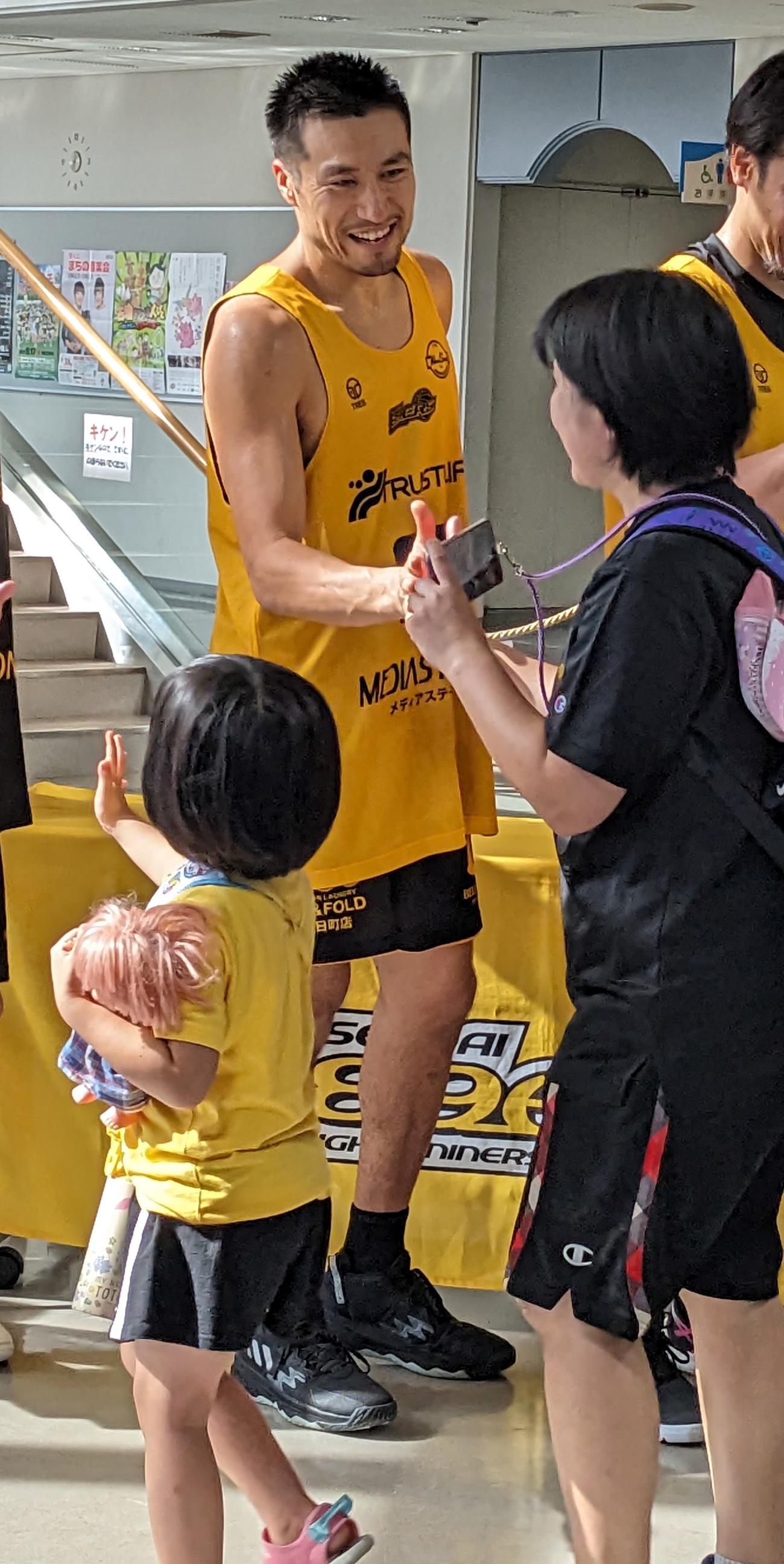 2日、ブースターと笑顔でハイタッチする片岡