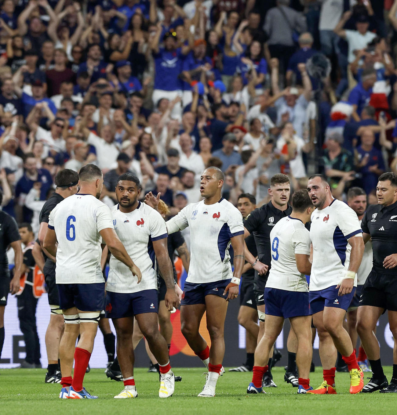 ラグビーW杯フランス大会の開幕戦でニュージーランドに勝利しタッチを交わすフランスの選手たち（共同）