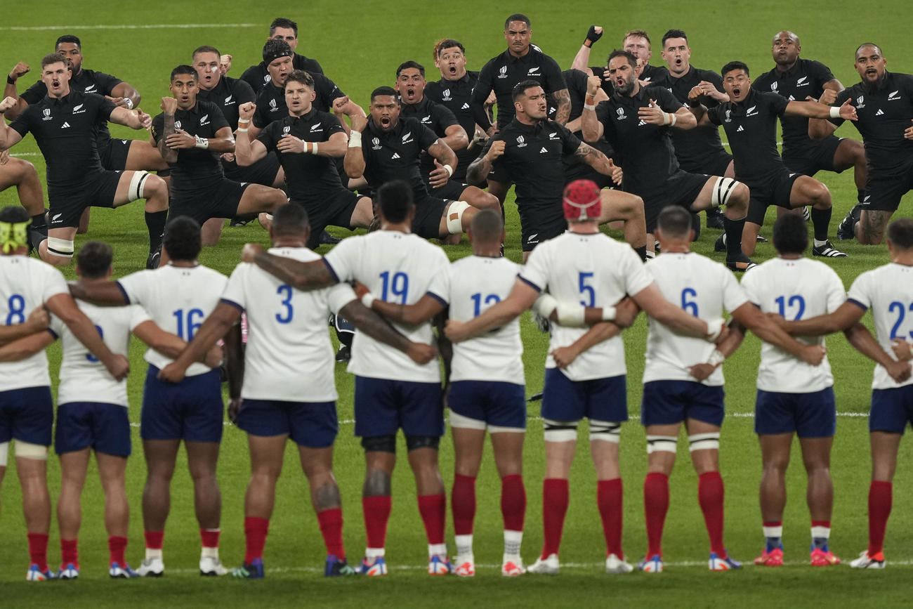 ラグビーW杯開幕戦、試合前にハカを披露するニュージーランドの選手たちと見つめるフランスの選手たち（AP）