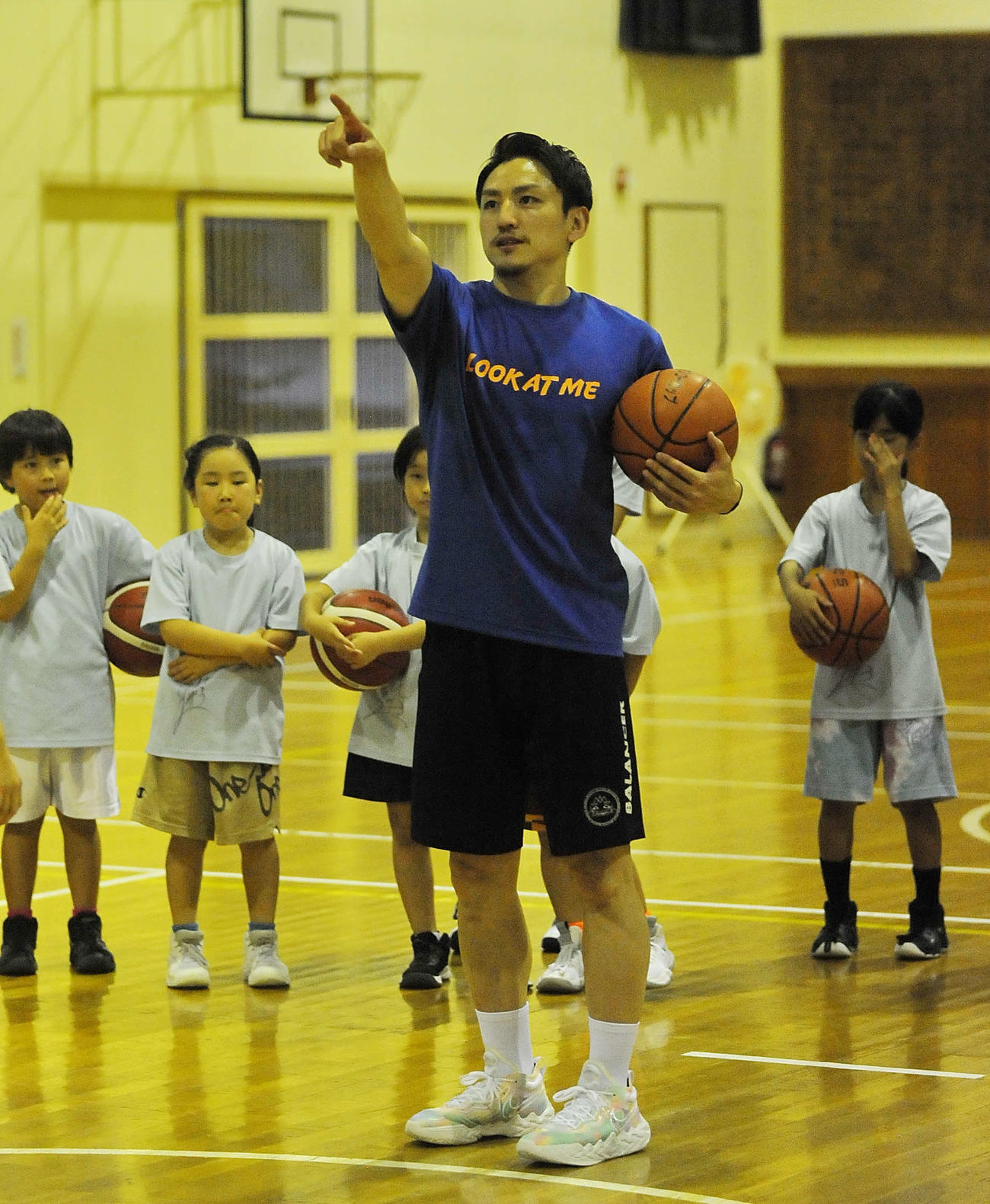 井宮北ミニバスの選手らにリングを指さしてシュート時のコツをアドバイスする大沢代表