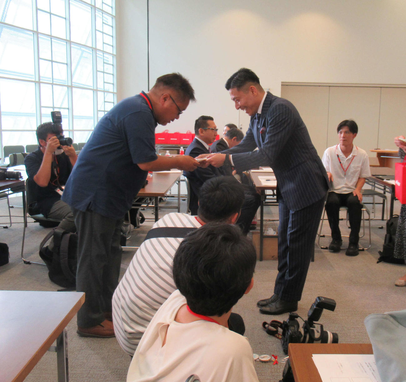 引退会見を前に、報道陣に対して、感謝のクッキーを渡す寺内健（右）（撮影・益田一弘）