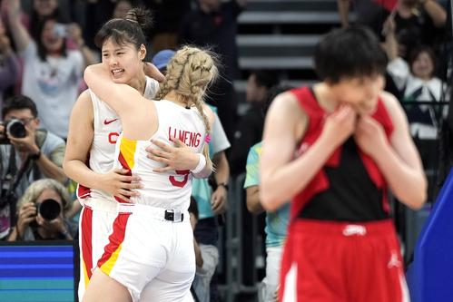 抱き合いながら歓喜する中国のセンター李月汝とフォワードのリー・メン(AP)