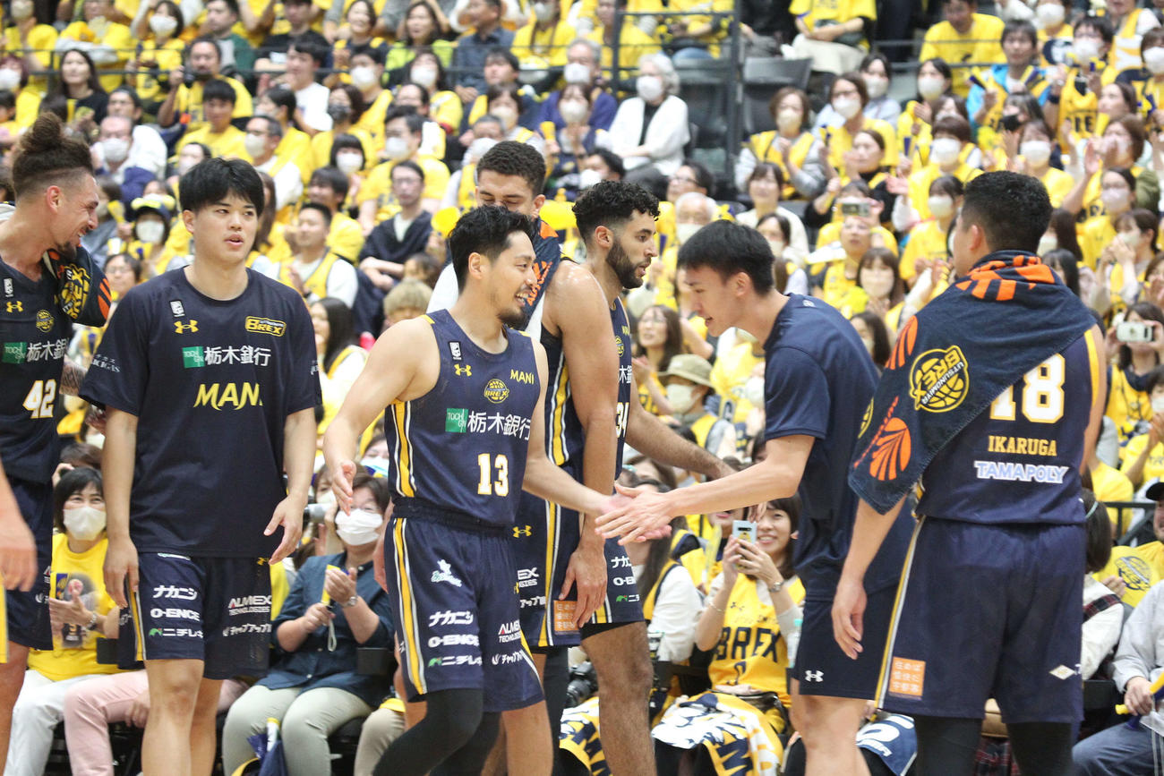 3Pシュートを決め、味方に出迎えられる宇都宮渡邉（撮影・沢田啓太郎）