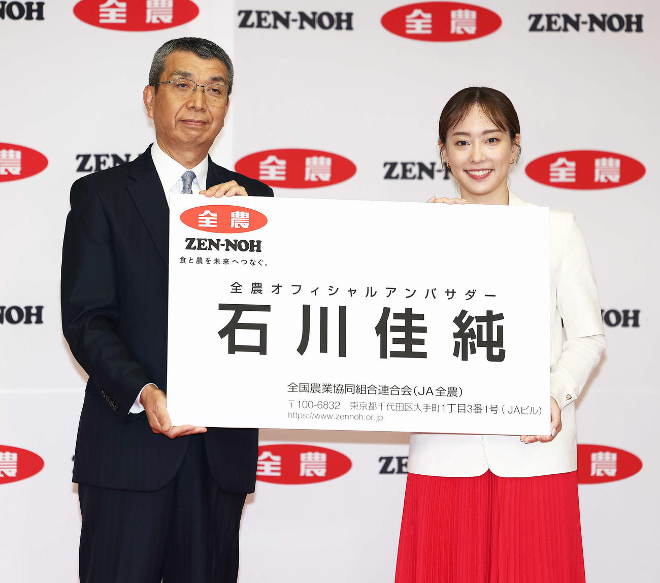 全農オフィシャルアンバサダーに就任し、野口理事長（左）から巨大名刺を受け取る石川佳純さん（撮影・河田真司）