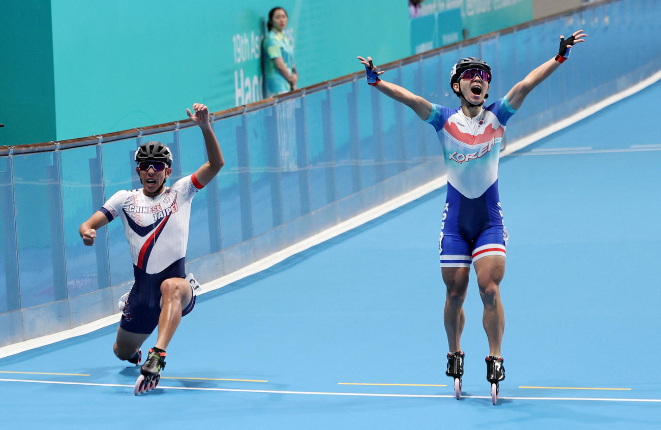 10月3日に開かれた台湾全国体育大会男子1000メートルの決勝ゴール前、ガッツポーズする韓国の選手、左は1位になった台湾代表の黄玉霖（ロイター）