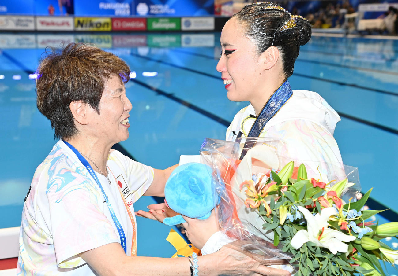 世界水泳2023福岡大会　アーティスティックスイミング女子ソロ・フリーで優勝し、井村雅代コーチ（左）から花束を贈られて言葉を交わす乾友紀子（2023年7月19日撮影）