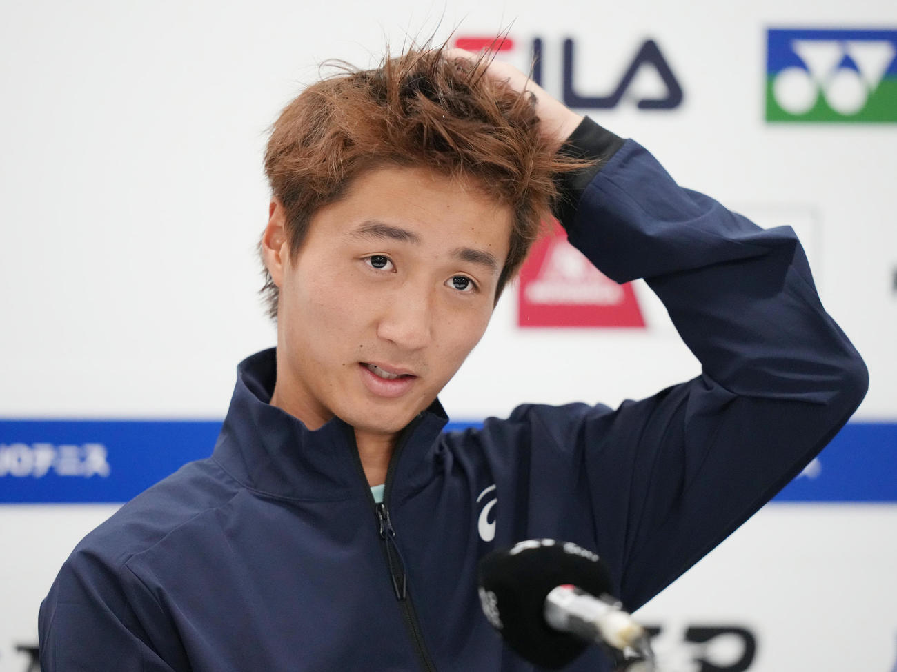 男子シングルスで決勝進出を逃した望月は会見で悔しげな表情（撮影・鈴木みどり）