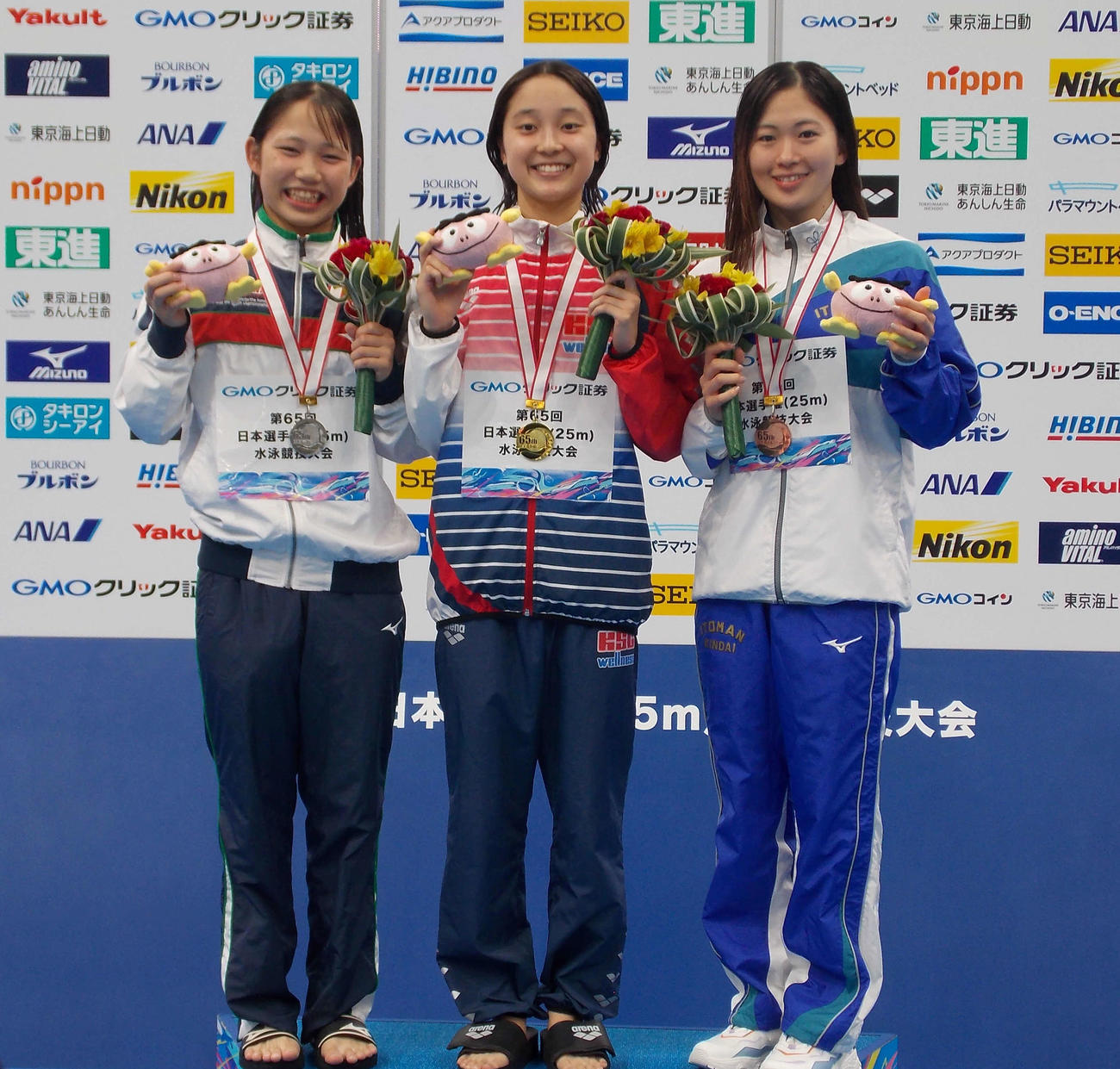 競泳短水路日本選手権の女子400メートル個人メドレーを制した成田実生（中央）と2位の鈴木彩心（左）、3位の谷川亜華葉（撮影・松本航）