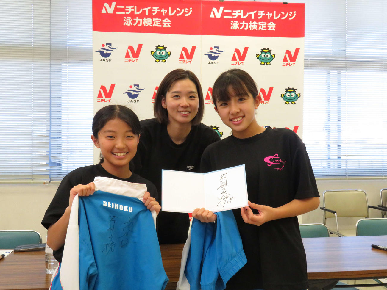 泳力検定k会参加者との記念撮影に笑顔で応じる寺村美穂さん（中央）