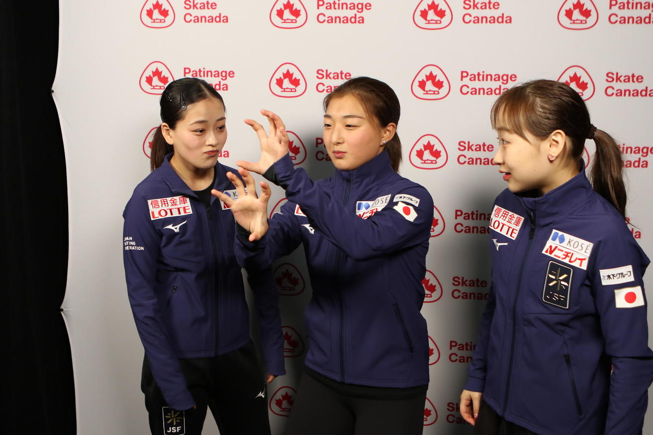 3人のポーズを考える渡辺、坂本、松生（左から）