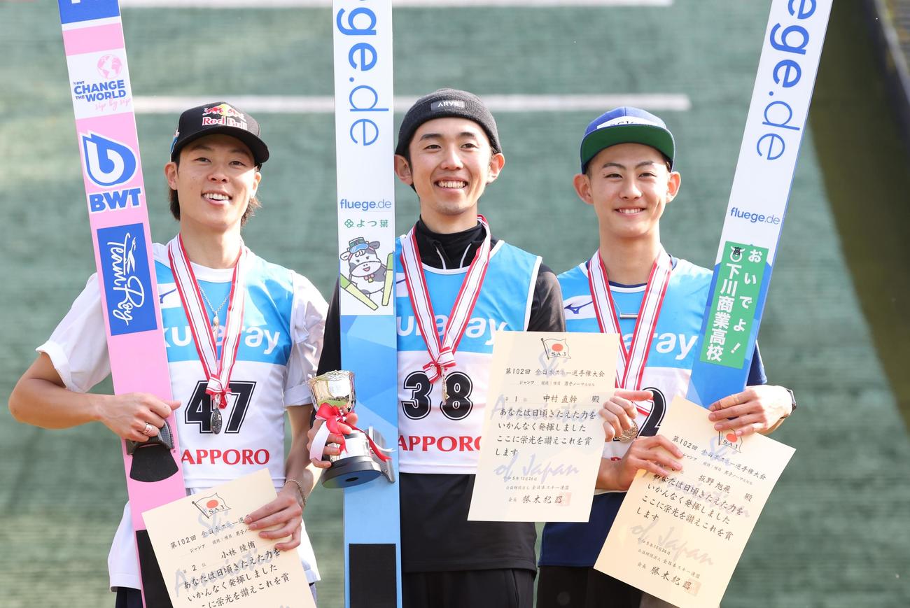 男子ノーマルヒル　優勝し笑顔の中村（中央）。左は2位小林陵、右は3位坂野（撮影・黒川智章）