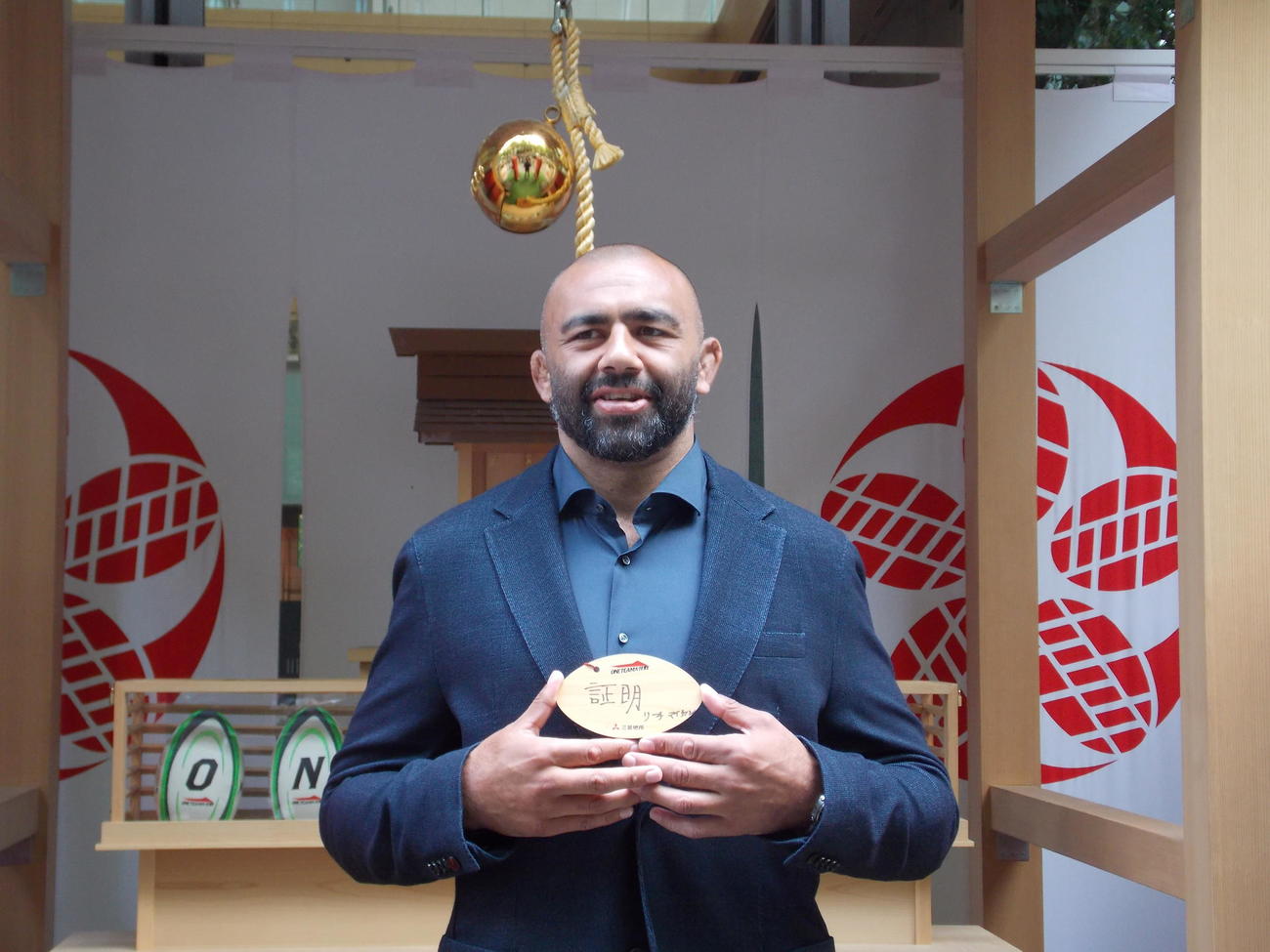 丸の内ラグビー神社を訪れ、大会前に納めた絵馬を手にするW杯日本代表のリーチ・マイケル（撮影・松本航）