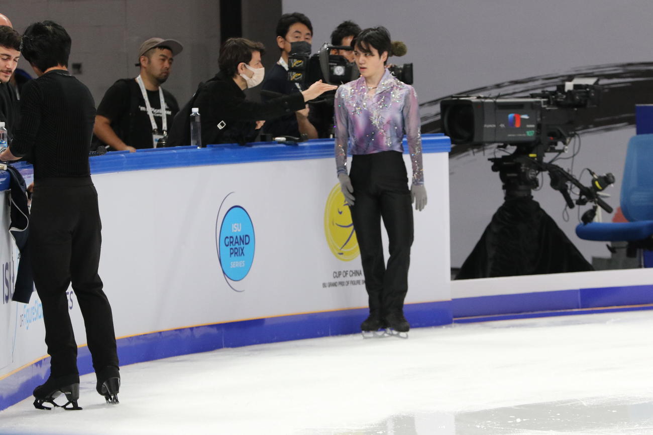 ショートプログラム（SP）前の公式練習でステファン・ランビエル・コーチ（右から4人目）と話す宇野昌磨（右）