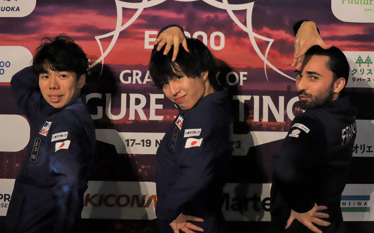 メダリスト会見前にエイモズ（右）考案のポーズを取る佐藤（左）と三浦