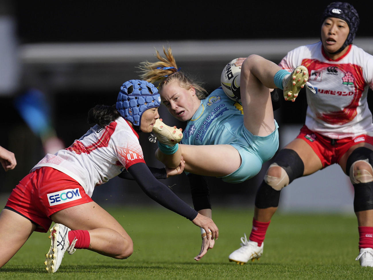 女子1次リーグ日本－カザフスタン　前半、タックルする平野（左）（共同）