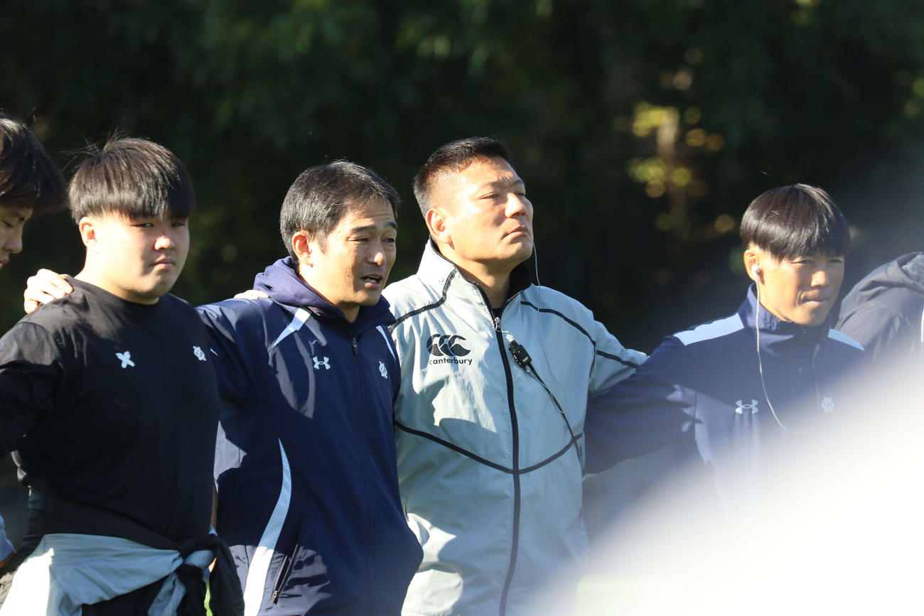 塾歌を歌う前に円陣を組む青貫監督（左から2人目）