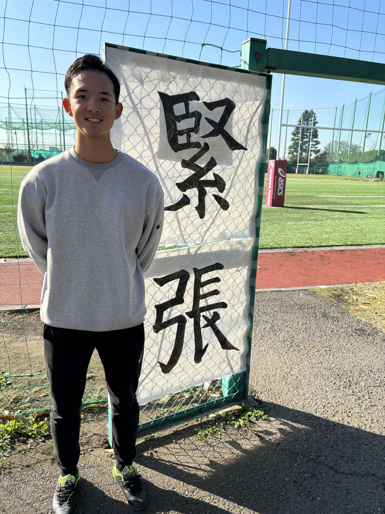 慶大戦を翌日に控え、練習場の前で笑顔を見せる早大トレーナーの水島直也（撮影・松本航）