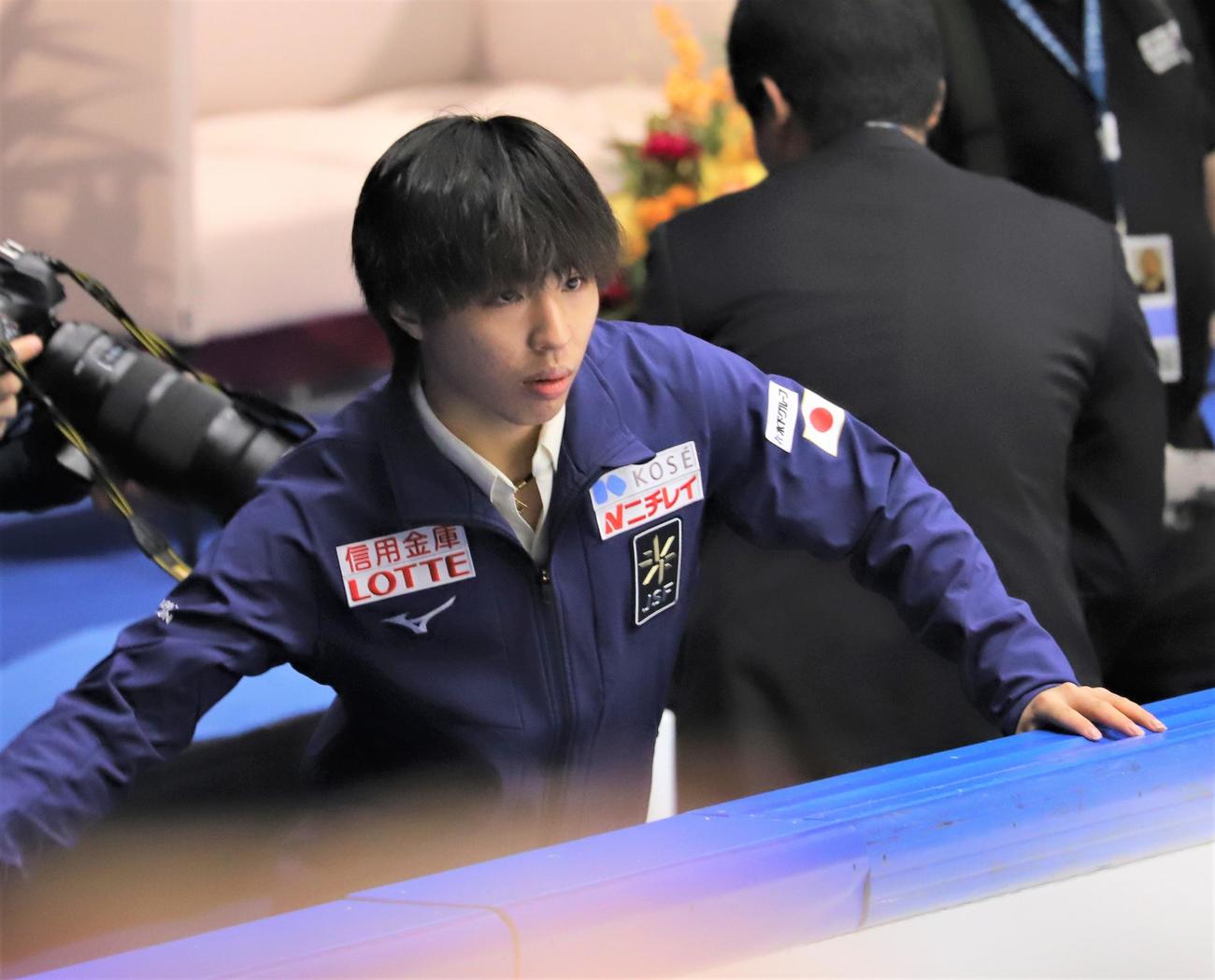 フィギュアスケートGPシリーズフィンランド大会　男子フリーで佐藤駿の演技を見終えて表情を引き締める三浦佳生（2023年11月18日撮影）