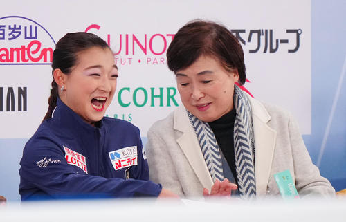 女子SPの演技後、キス・アンド・クライで笑顔を見せる坂本（左）。右は中野コーチ