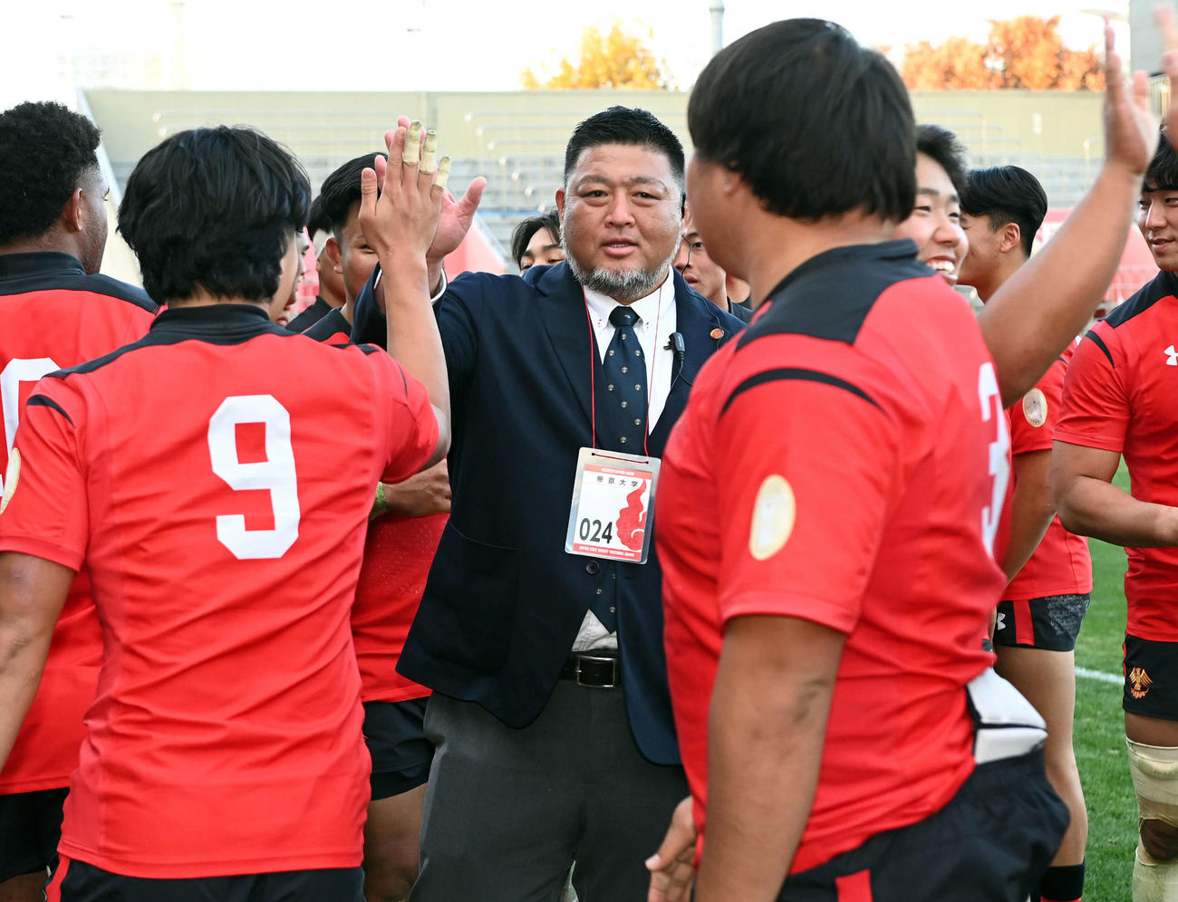 帝京大対慶大　優勝を飾り選手とハイタッチをする帝京大・相馬監督（撮影・たえ見朱実）