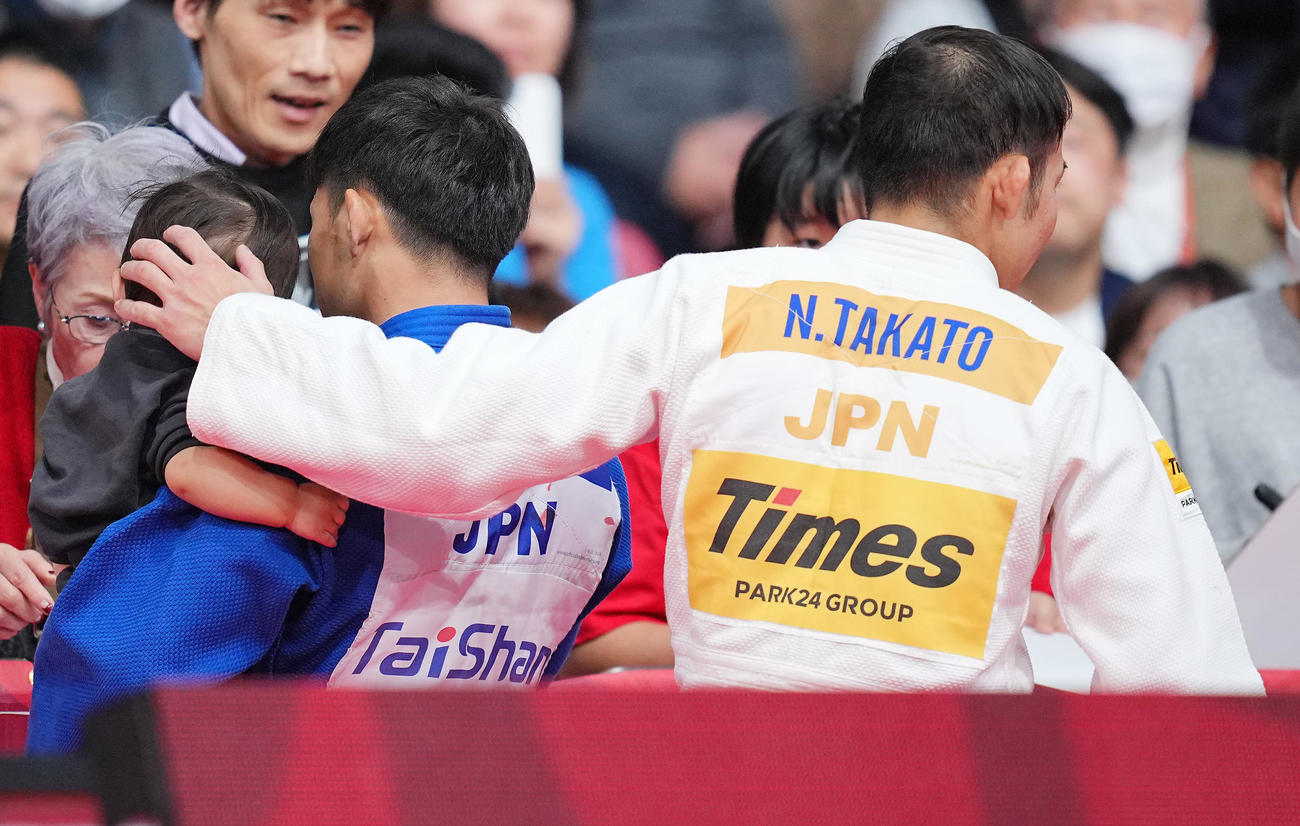 男子60キロ級で優勝を決め永山が抱く子どもの頭をそっとなでて引き揚げる高藤（撮影・垰建太）