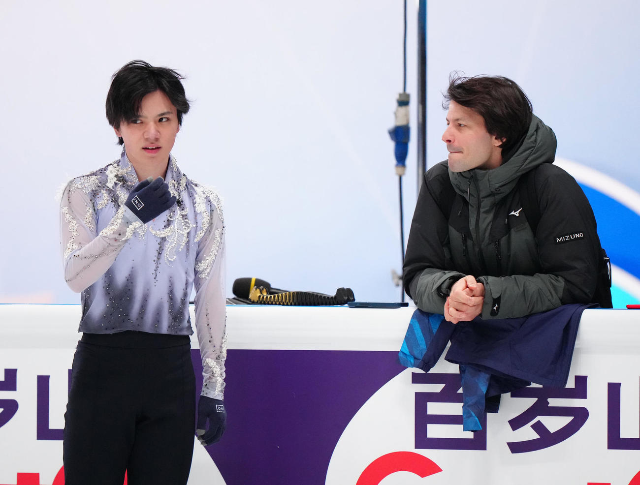 公式練習中、ランビエル・コーチ（右）と言葉を交わす宇野