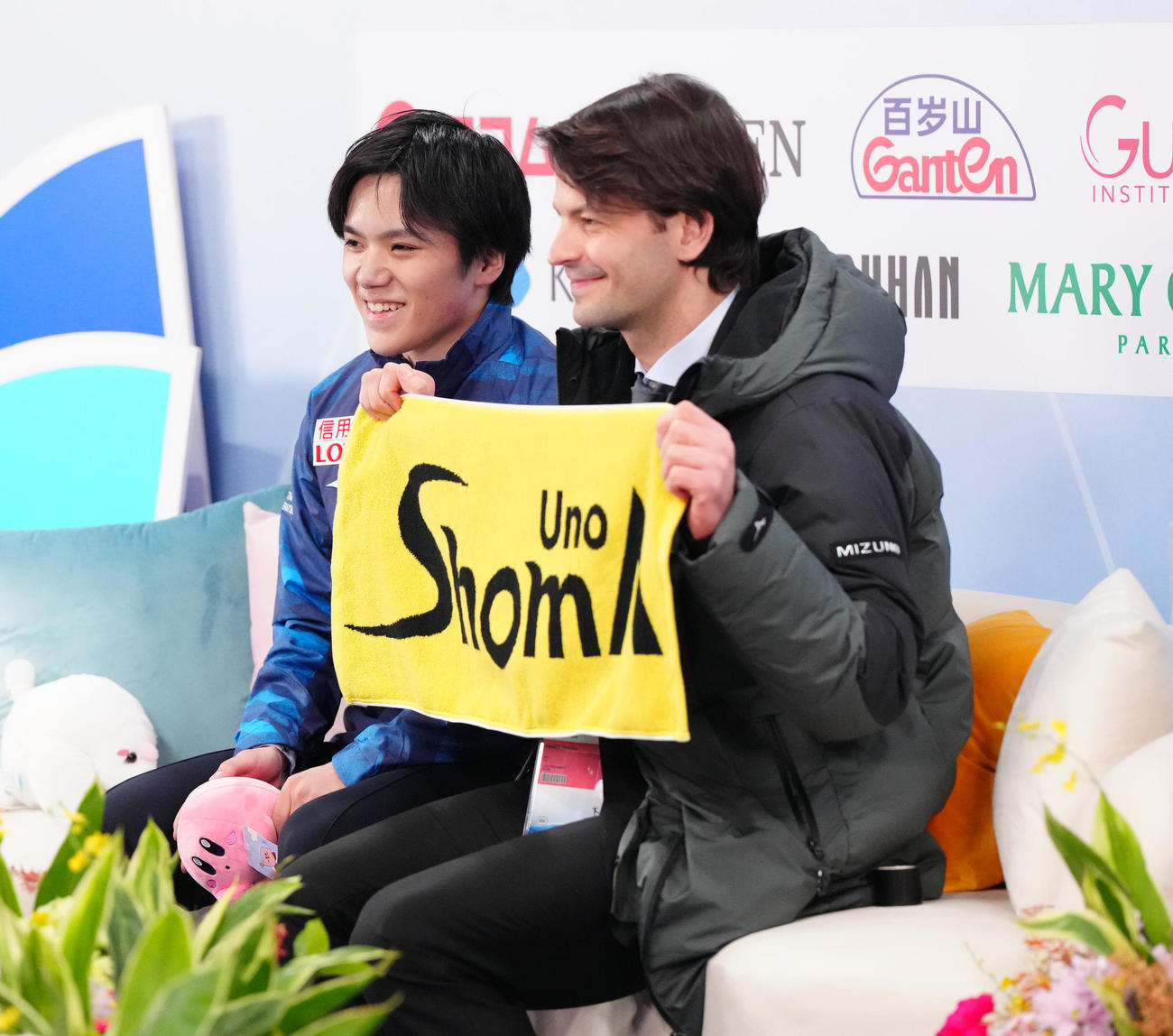 男子SPの演技後、キス・アンド・クライで笑顔を見せる宇野（左）。右はタオルを掲げるランビエル・コーチ