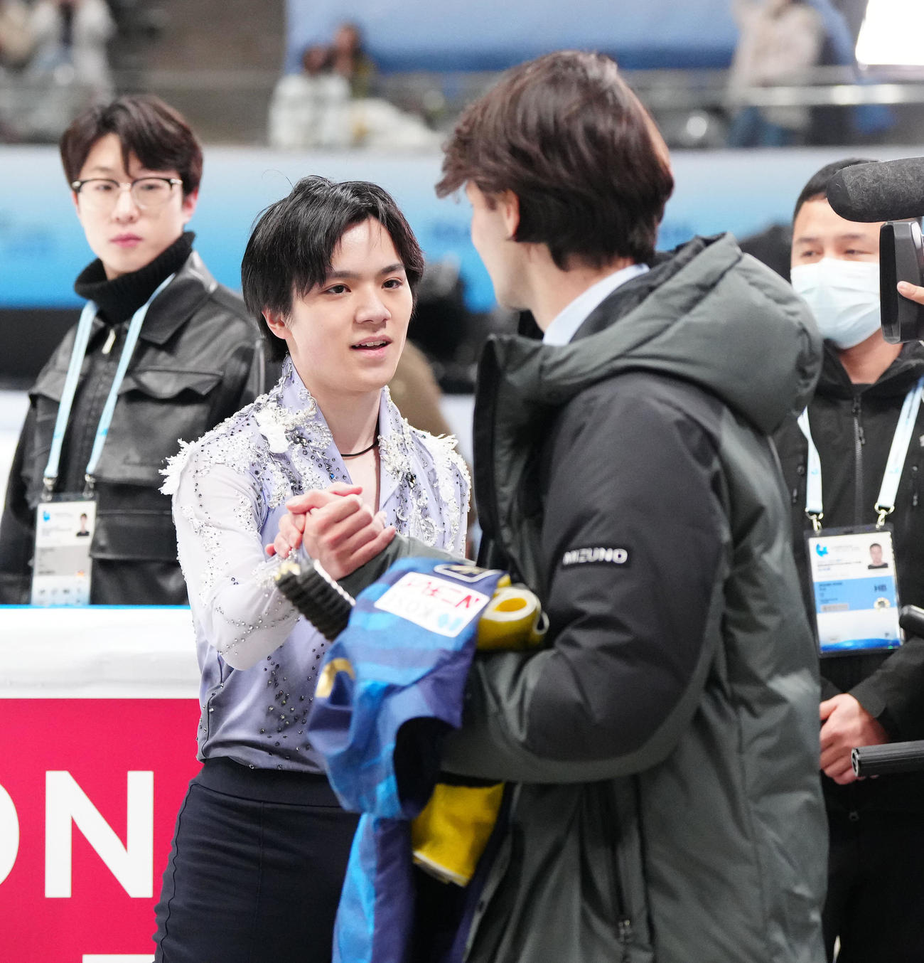 男子SPの演技後、ランビエル・コーチ（右）と握手を交わす宇野