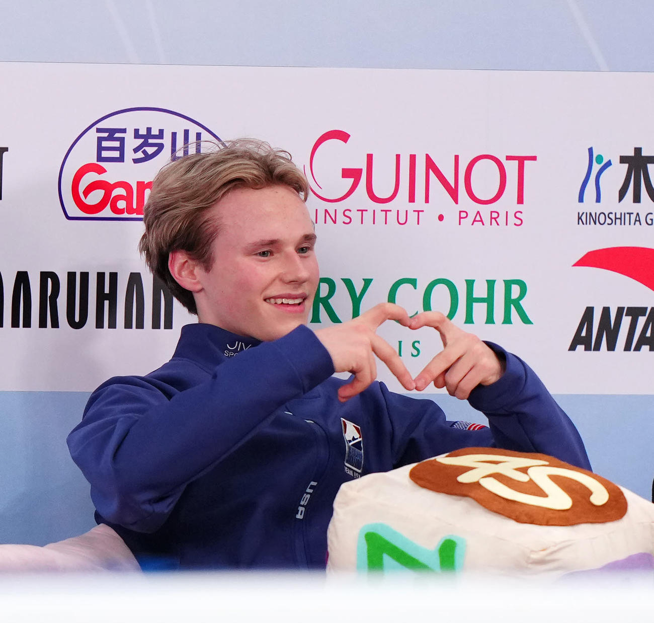 男子フリーの演技後、キス・アンド・クライでハートマークを見せるマリニン（撮影・江口和貴）