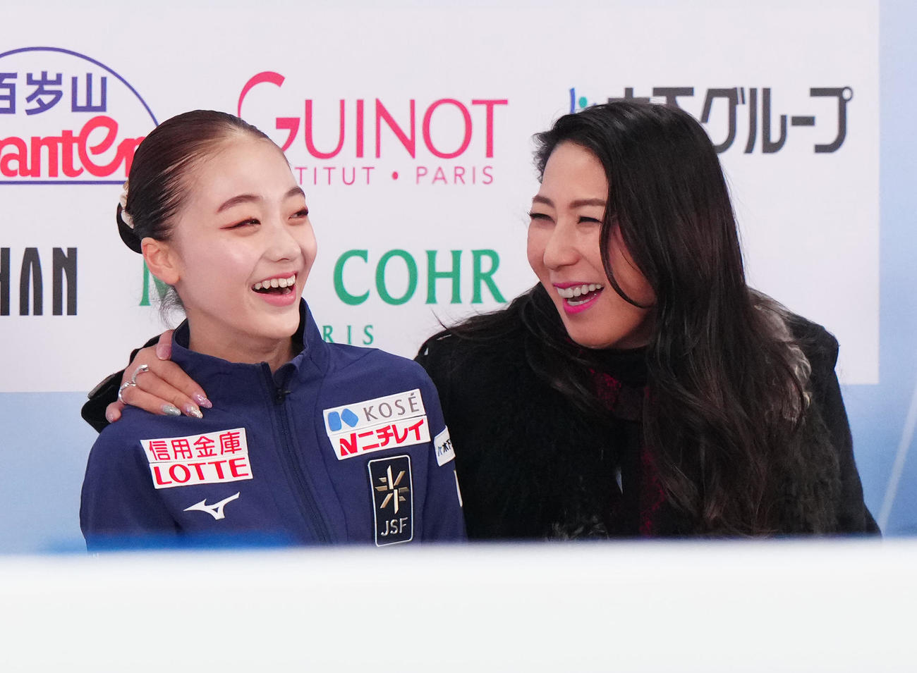 ジュニア女子フリーの演技後、キス・アンド・クライで笑顔を見せる上薗（左）。右は樋口コーチ（撮影・江口和貴）