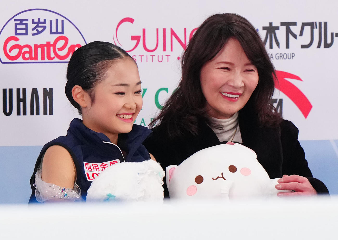 ジュニア女子フリーの演技後、キス・アンド・クライで笑顔を見せる島田（左）。右は浜田コーチ（撮影・江口和貴）