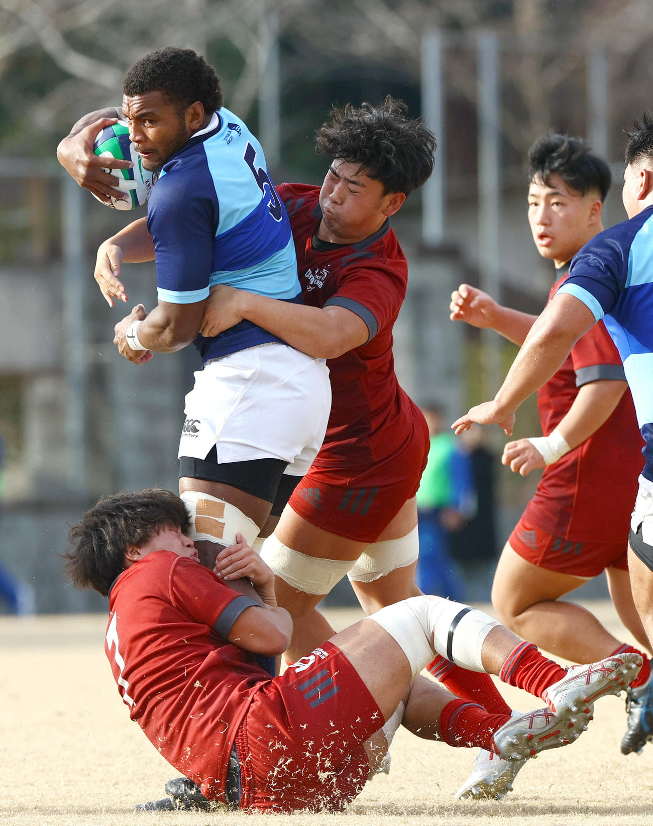 摂南大対龍谷大　前半、相手タックルを受けながらもボールをキープする摂南大ロックトゥポウ（左）（撮影・上山淳一）