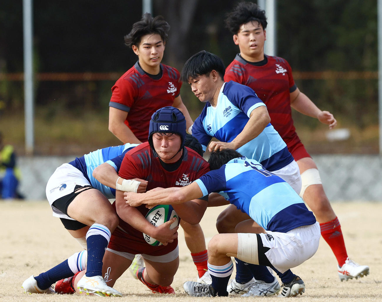 摂南大対龍谷大　前半、龍谷大NO8平野（手前）の攻撃をタックルで止める摂南大の選手たち（撮影・上山淳一）