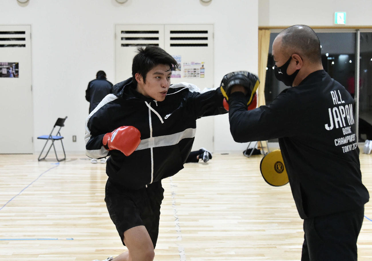 仁多見監督を相手にミット打ちをする川村
